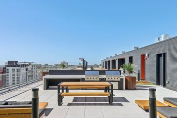 A modern outdoor seating area with benches and tables.